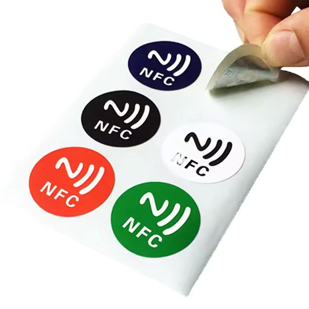 A sheet of round NFC stickers in five colours, one being peeled up.