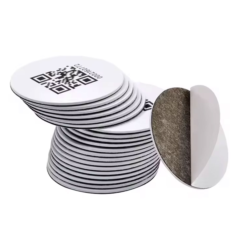 A stack of round adhesive NFC tags, one turned to show its backing.